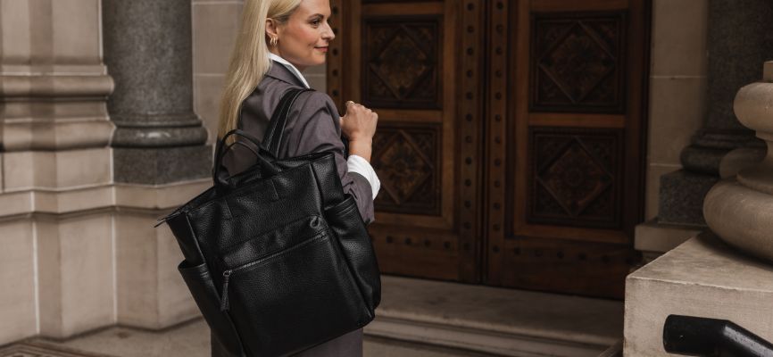 Woman stands in front of building with Bronx Backpack slung over shoulder