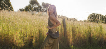 Travel Crossbody Bag is slung across woman's chest, as she stands in a field