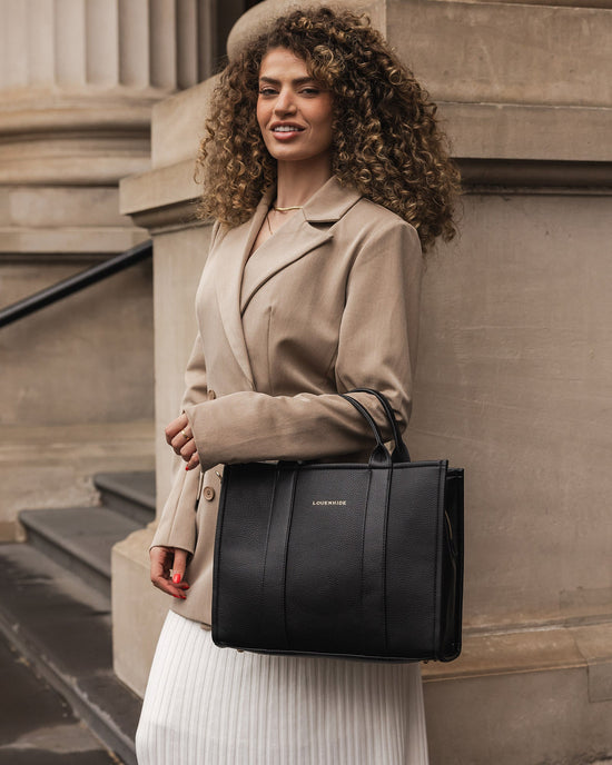 Louenhide Manhattan Tote Bag in black vegan leather styled with blazer and skirt for work