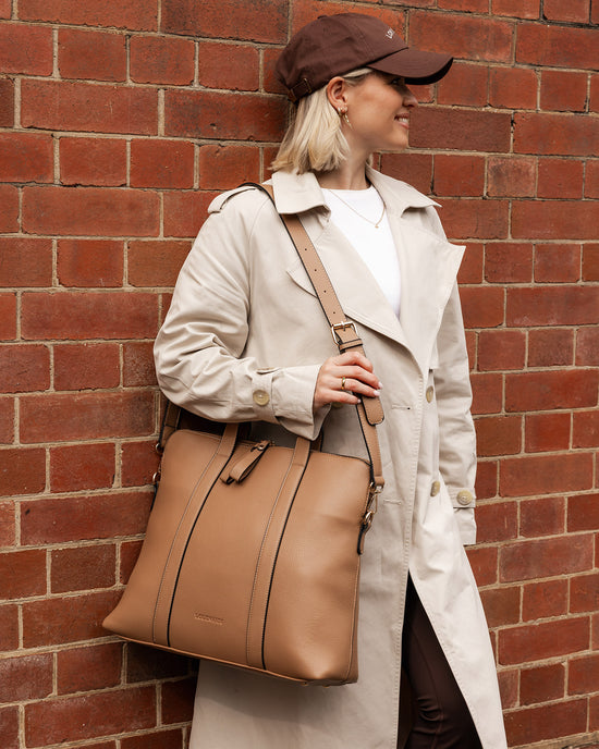 Louenhide Rhodes Tote Bag in latte vegan leather styled for work commute with coat and cap