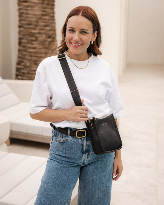 Louenhide Parker Crossbody Phone Bag in black vegan leather is styled with white tee and denim