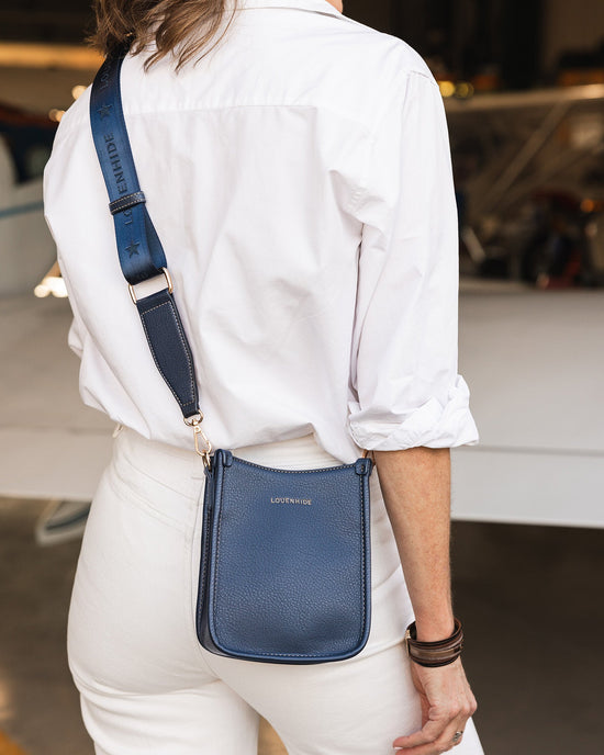 Louenhide Parker Blue Phone Bag is worn crossbody behind woman's back