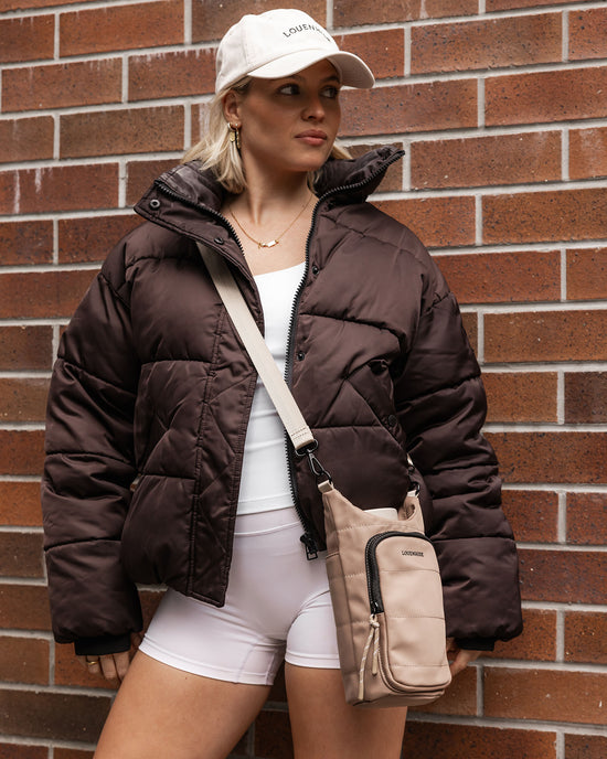 Louenhide Miami Water Bottle Bag in beige nylon is paired with puffer jacket and bike shorts