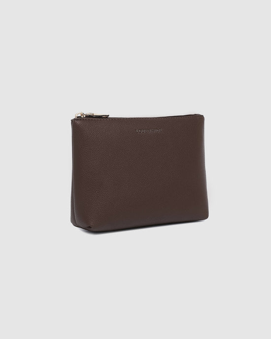 The Everyday Pouch - Chocolate - angle view, made from vegan leather, stands upright on a plain light grey background.
