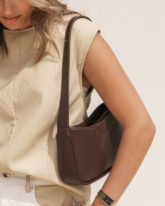 Louenhide Ivy Chocolate Shoulder Bag is styled with beige linen tank top and gold watch