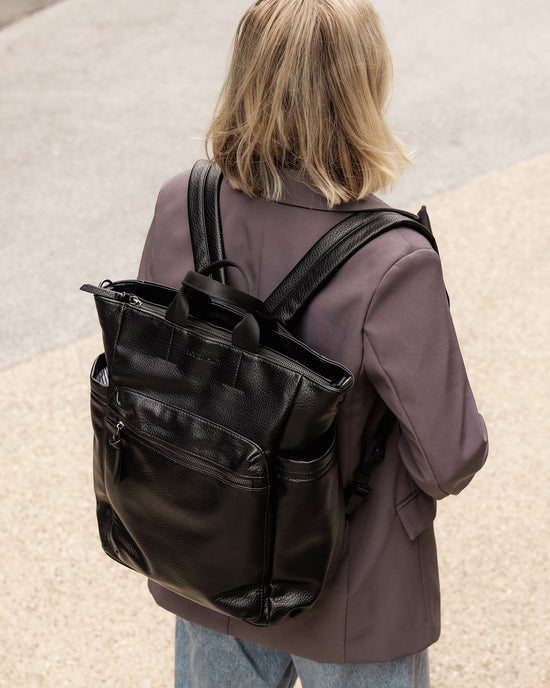 Louenhide Bronx Backpack in black vegan leather styled with grey blazer in uni setting