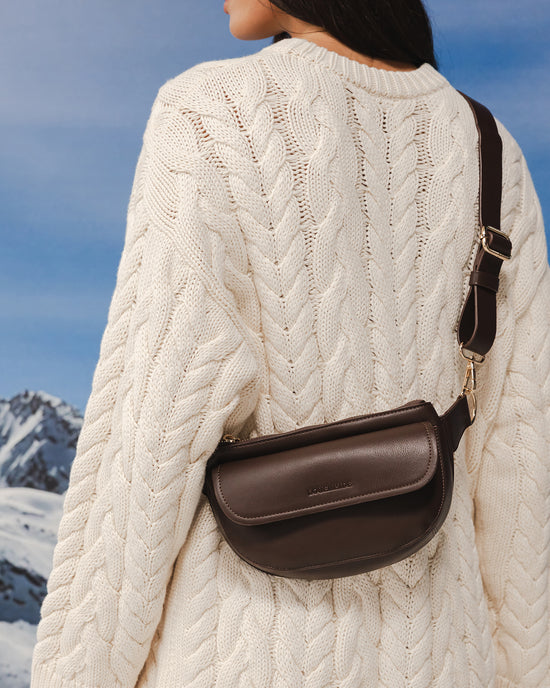 Woman wears Chocolate Lola Belt Bag as sling bag, draped around chest