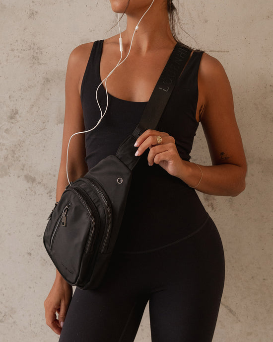 Louenhide Boyd Sling Bag in Black styled with activewear for weekend errands