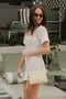 Butter Yellow Baby Sophie Crossbody Bag hands from woman's shoulder as she stands poolside
